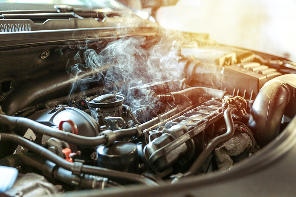 Steam rises from an overheating engine that needs auto repair