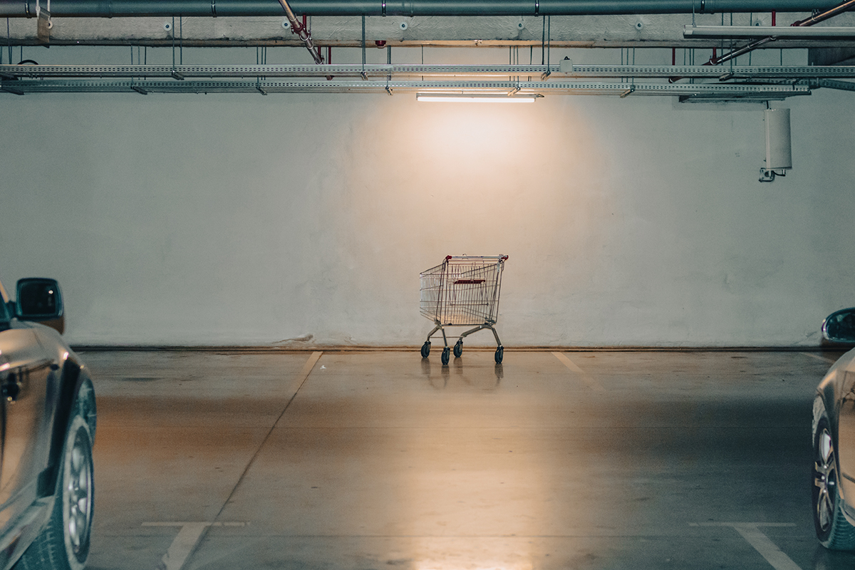 A rogue shopping cart sits unattended in a parking garage