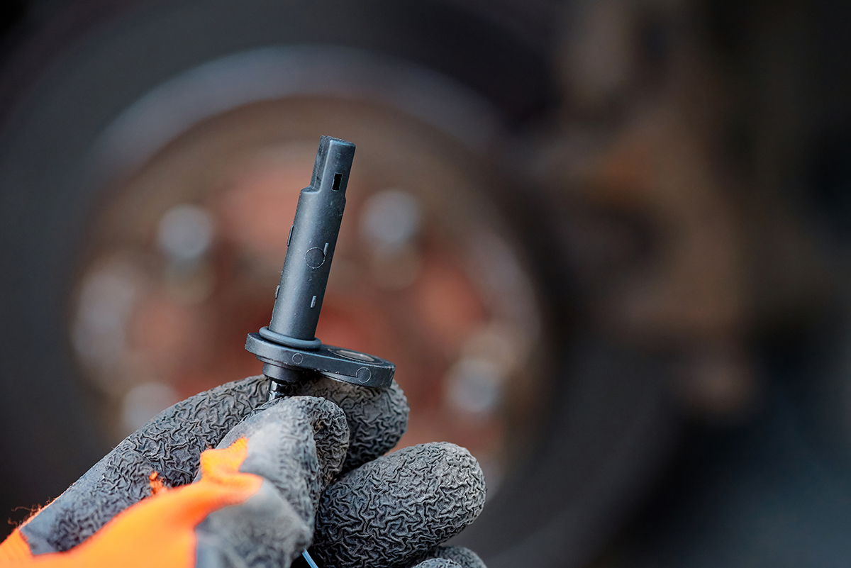 Mechanic inspects an ABS sensor during brake system diagnostics