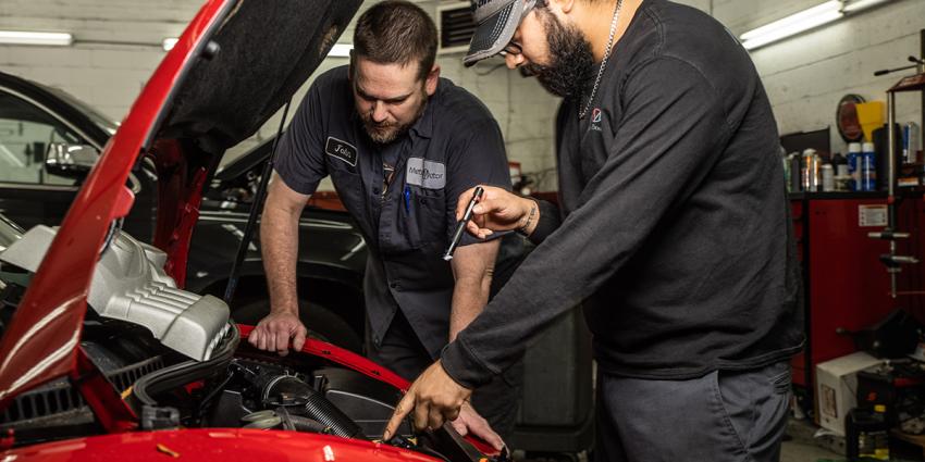 Two auto repair service technicians inspect a vehicle at Metro Motor in D.C.