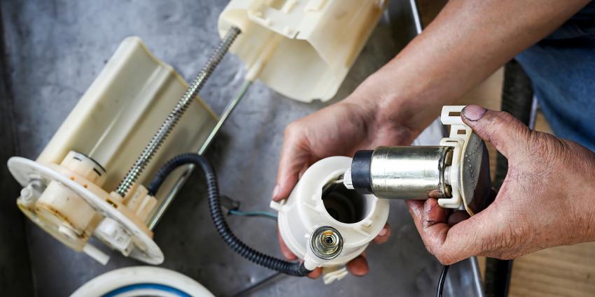 Auto repair technician dismantles a failing fuel pump