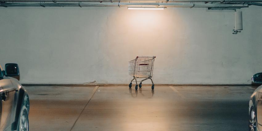 A rogue shopping cart sits unattended in a parking garage