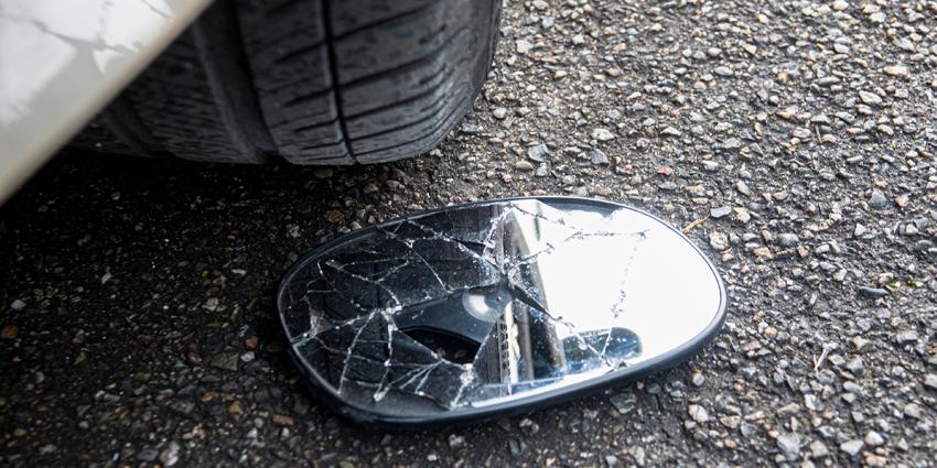 Broken sideview mirror lays on the ground after a sideswipe incident