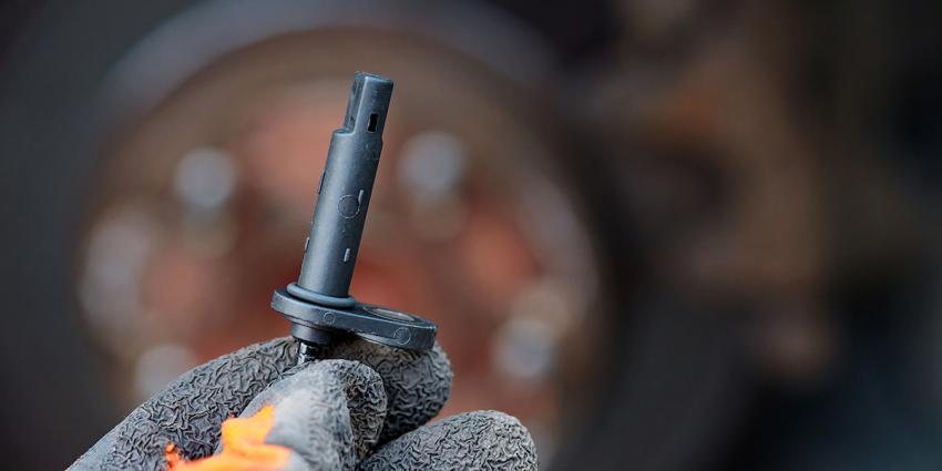 Mechanic inspects an ABS sensor during brake system diagnostics